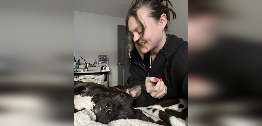 Dog and his adopter laying on the bed