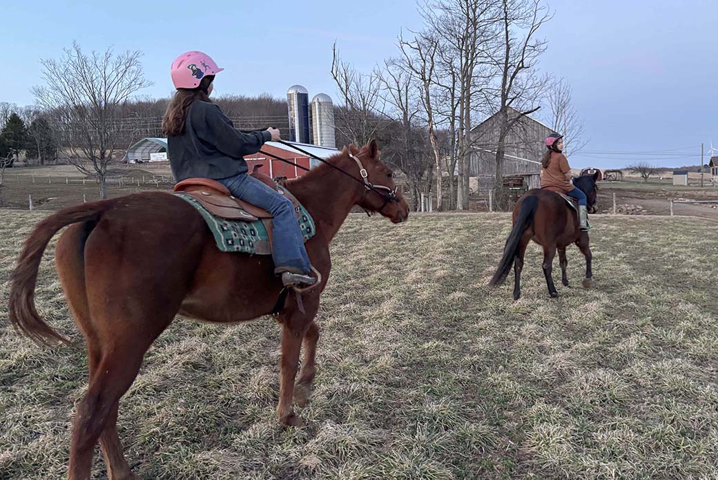 Two girls riding horses